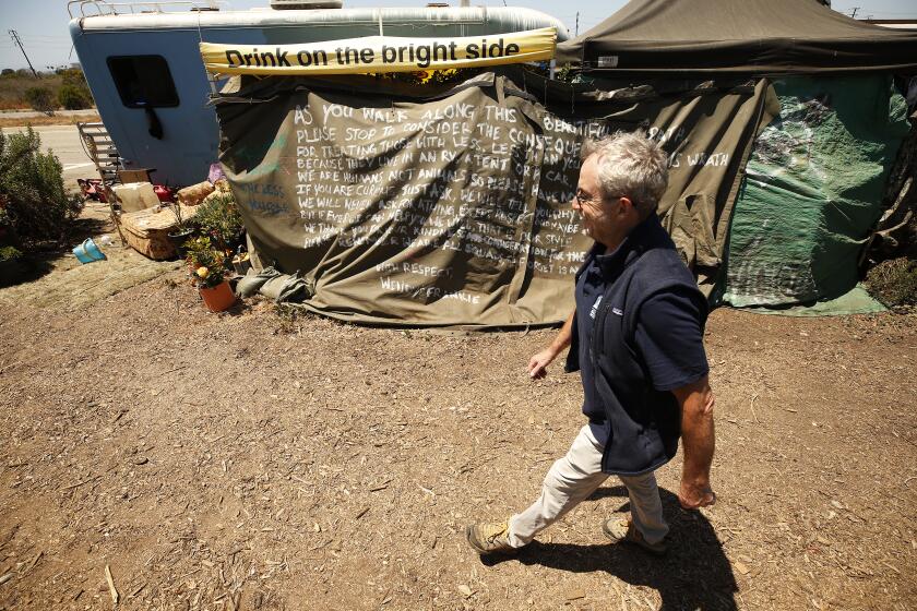 LOS ANGELES, CA - JUNE 11: Scott Culbertson, executive director of Friends of the Ballona Wetlands walks past signs placed on campers as he gives a tour of some of the destruction caused by homeless encampments that are encroaching on the Freshwater Marsh in Ballona Wetlands. Play Del Rey on Friday, June 11, 2021 in Los Angeles, CA. (Al Seib / Los Angeles Times).