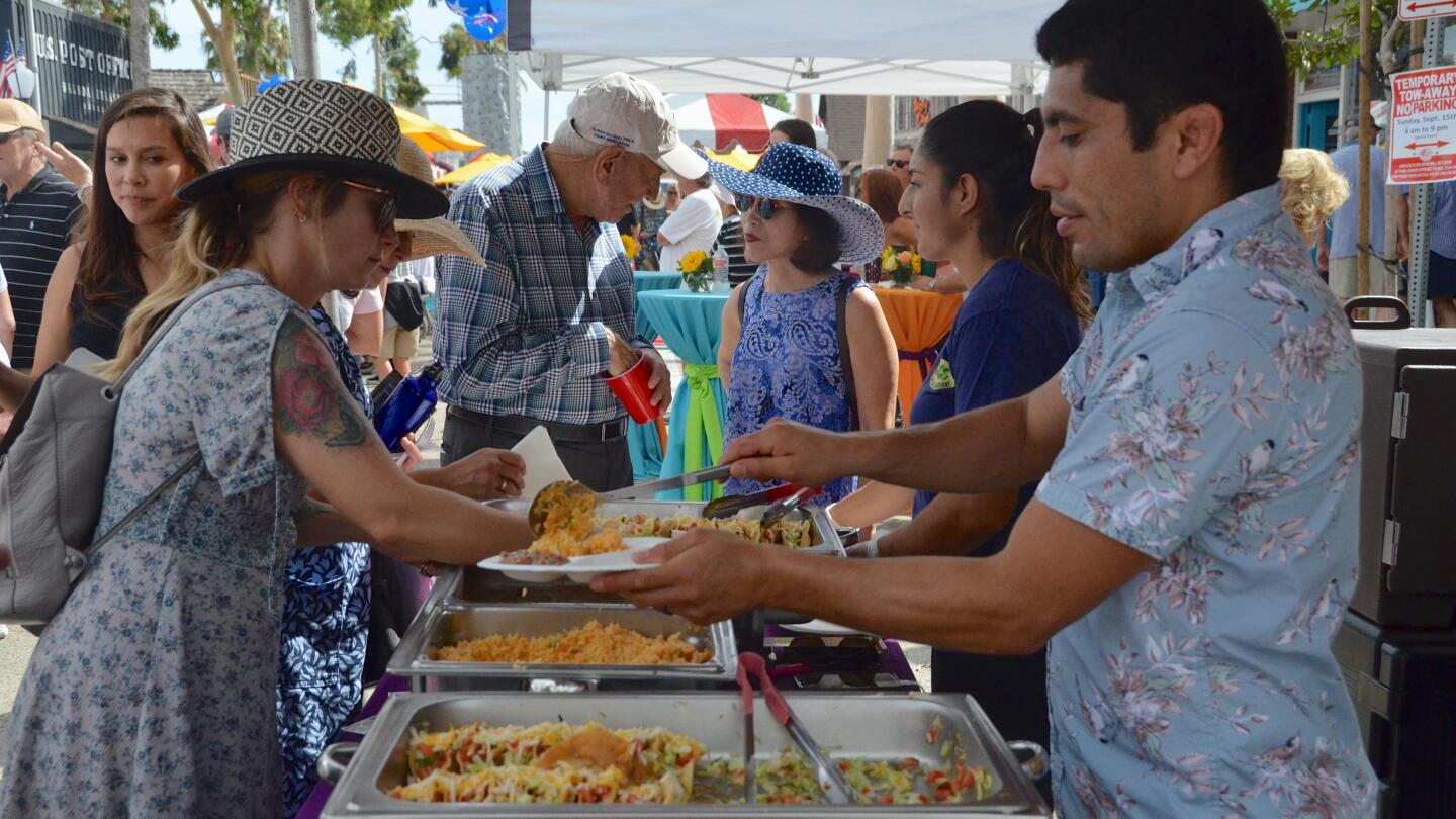 Picante Martin's serves tacos, beans and rice during the Balboa Island Carnival & Taste of the Island on Sunday on Marine Avenue.