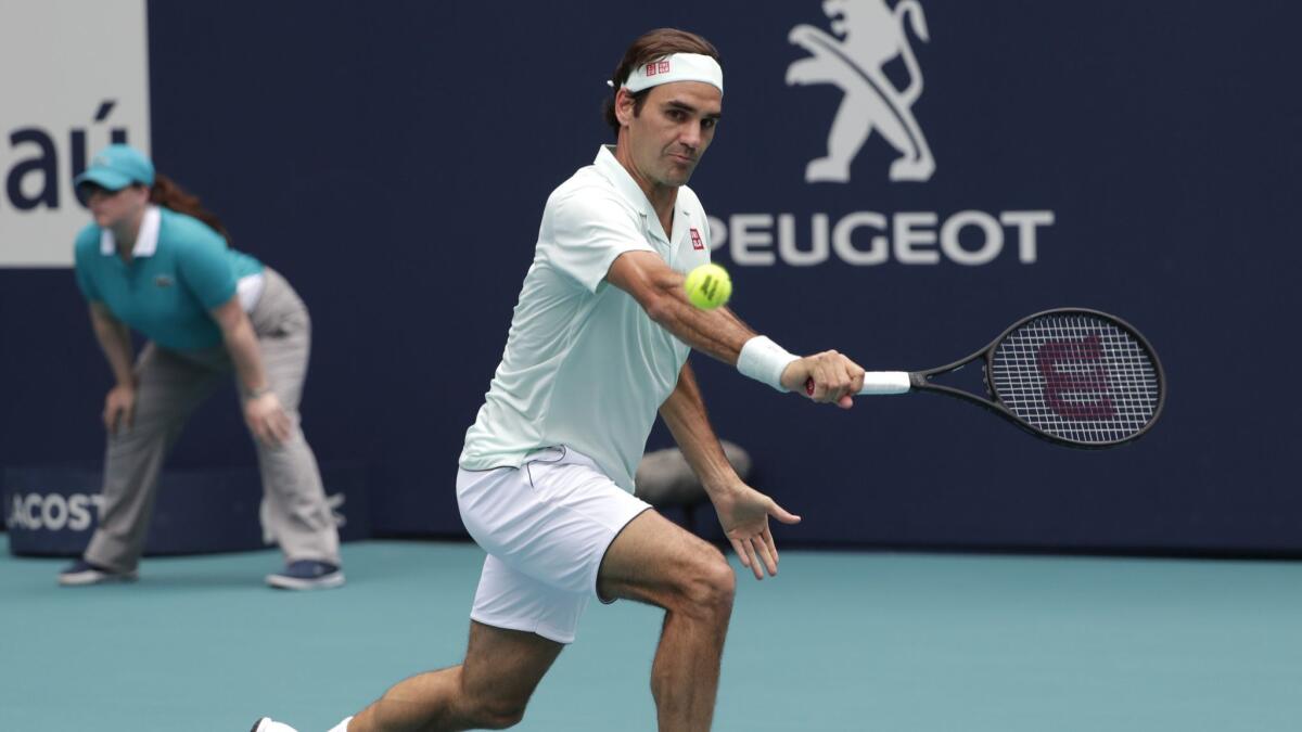Roger Federer returns to John Isner during their championship singles match at the Miami Open on Sunday.