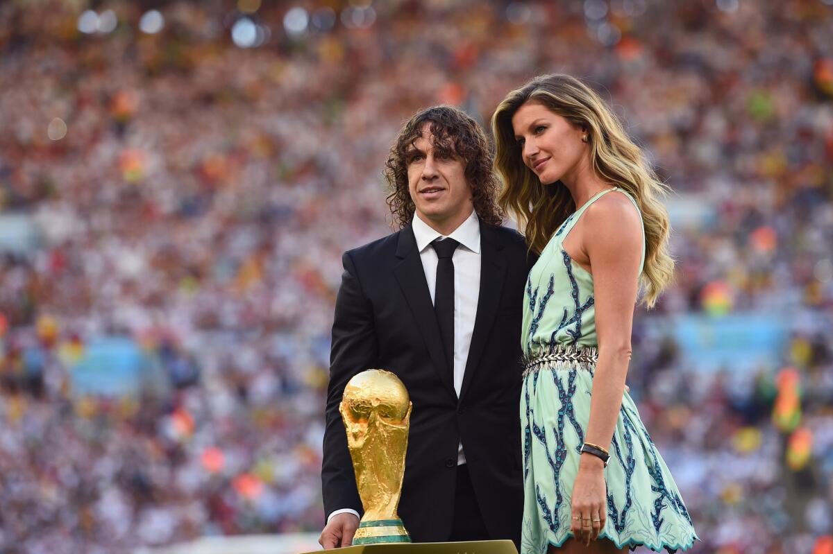 Carles Puyol and Gisele Bundchen present the World Cup trophy before the final World Cup match, in which Germany went on to defeat Argentina 1-0.