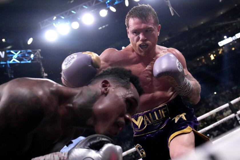 Canelo Alvarez, of Mexico, right, hits Jermell Charlo during their super middleweight title.