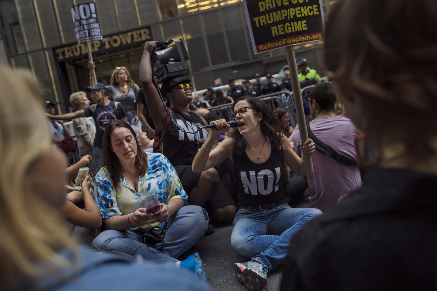 Protesters shout slogans and hold signs criticizing President Donald Trump in front of Trump Tower in New York on Aug. 14, 2017, ahead of his first visit to the building since taking office.