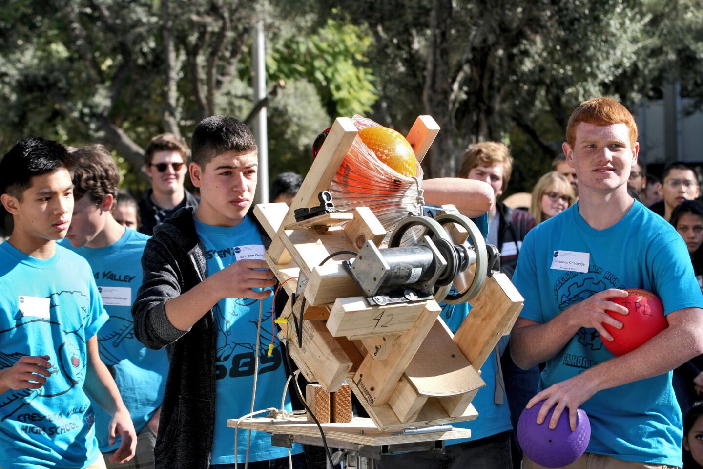 Members of the Crescenta Valley High School team (front, left to right: Lyron Co Ting Keh, Krikor Atachian and Joshua Kauffman) prepare to launch the ball at a target during the Jet Propulsion Laboratory Invention Challenge 2015 at JPL in La Cañada Flintridge on Friday, December 4, 2015. The team came in 4th place from more than 20 teams.
