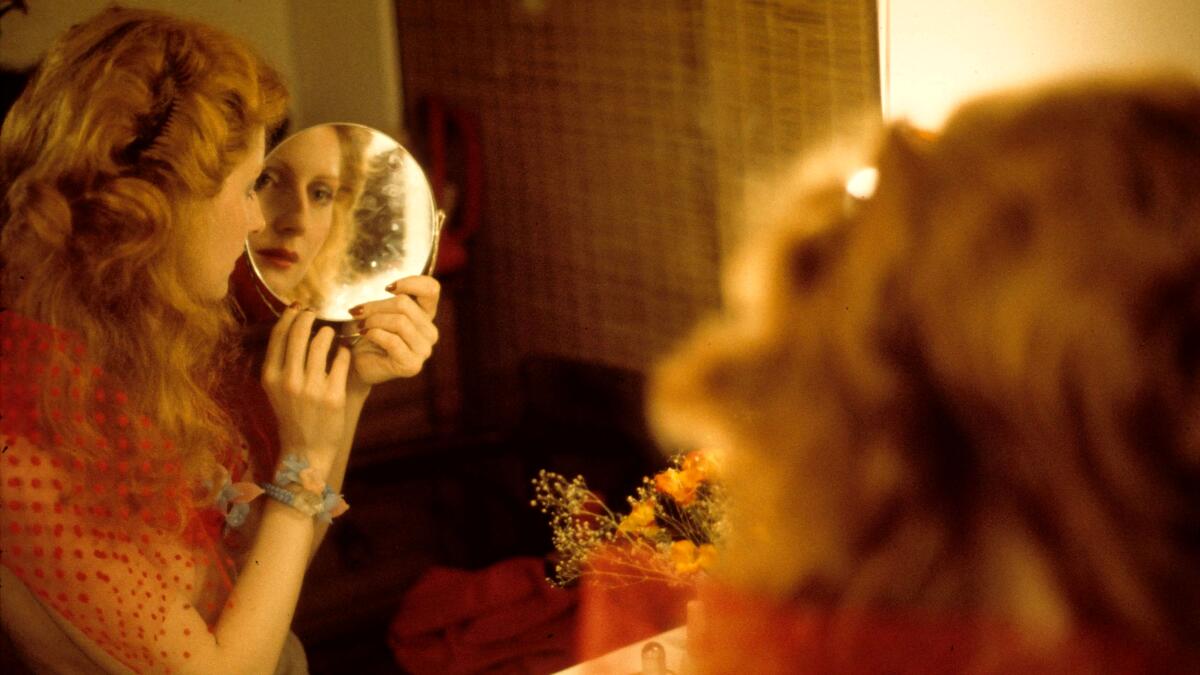 A woman looks into the mirror.
