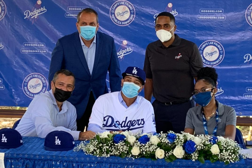 Prospect Wilman Diaz, center, signs with the Dodgers on Friday.