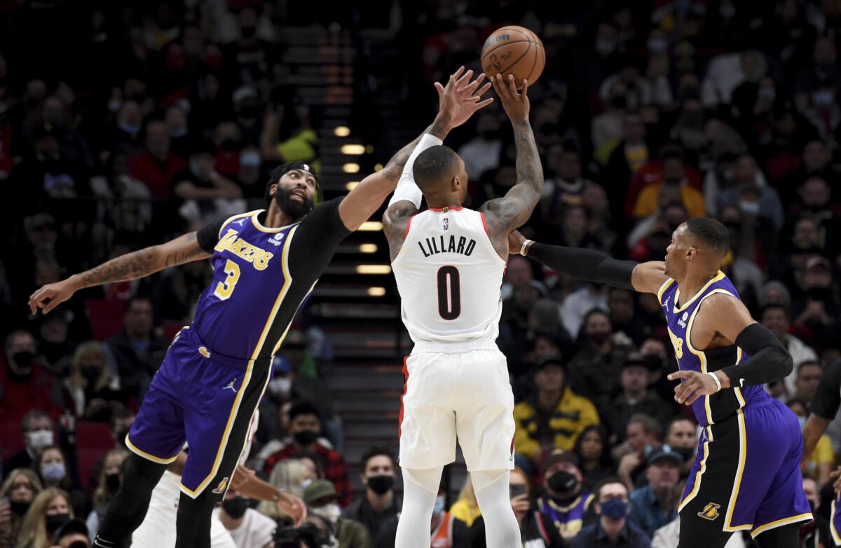 Portland's Damian Lillard (25 points) hits a three-pointer against the Lakers' Anthony Davis, left, and Russell Westbrook.