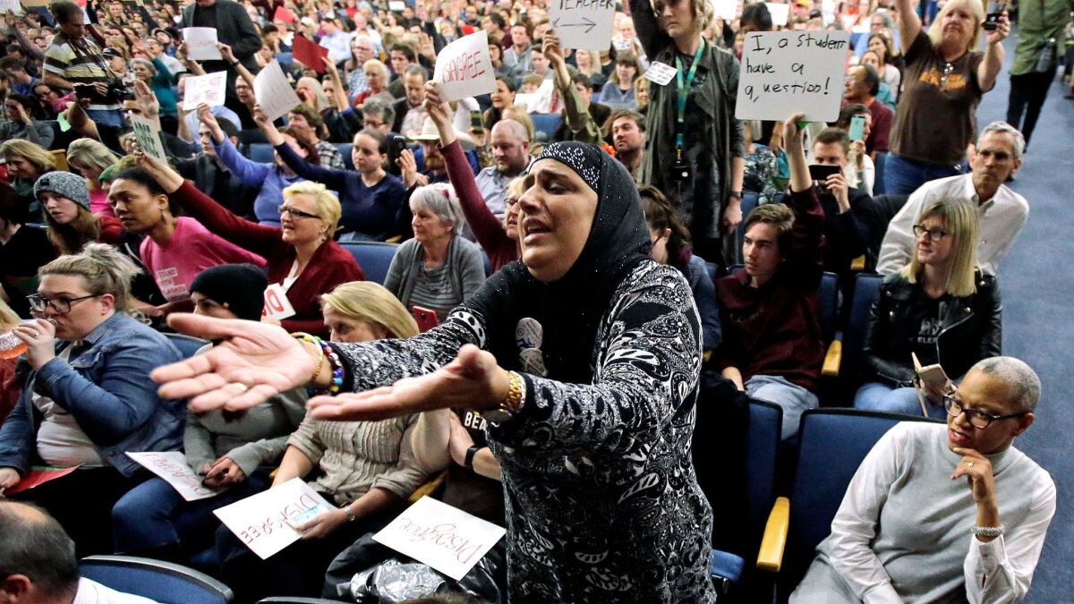 A woman reacts during a discussion of President Trump's travel ban at a town hall meeting at in Cottonwood Heights, Utah.