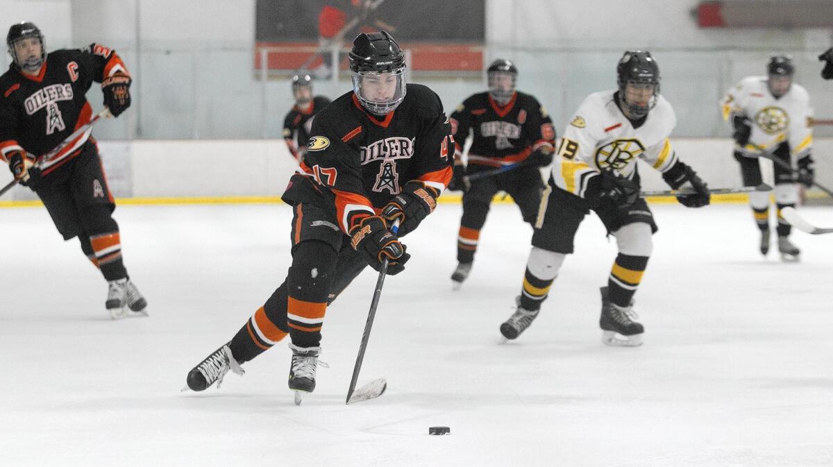 Huntington Beach High’s Kyle Baker drives the puck in for a goal against Long Beach Prep during the first half in a game at The Rink Lakewood Ice on Saturday. The Oilers won 5-4 as Baker helped the Oilers with four goals, including the game winner.