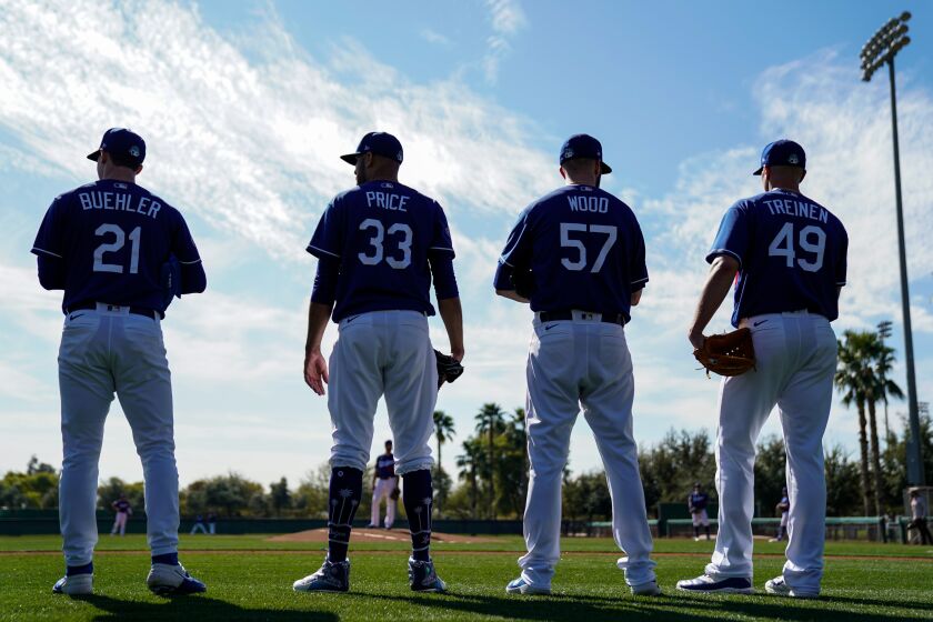 PHOENIX, ARIZ. - FEBRUARY 19: Los Angeles Dodgers Walker Buehler (21), David Price (33), Alex Wood (57) and Blake Treinen (49) talk with each other during Spring Training at Camelback Ranch on Wednesday, Feb. 19, 2020 in Phoenix, Ariz. (Kent Nishimura / Los Angeles Times)