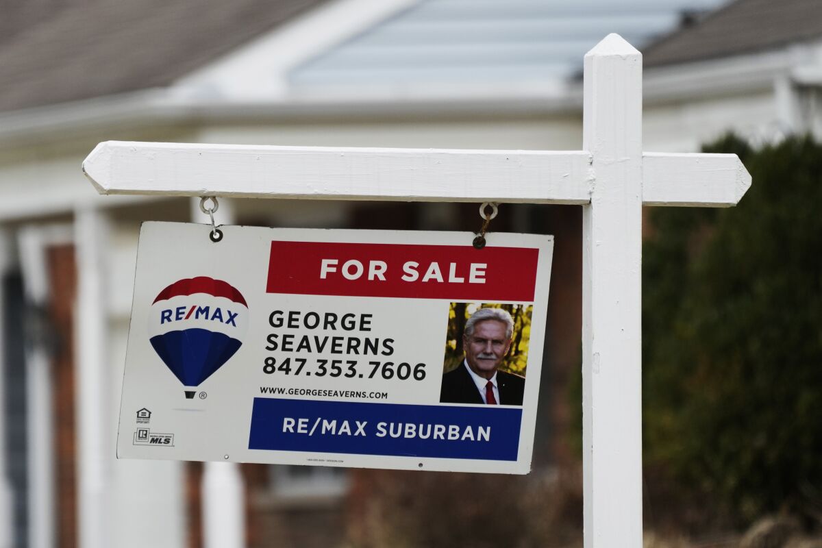 A for sale sign stands near homes in Buffalo Grove, Ill., Monday, March 20, 2023. On Thursday, Freddie Mac reports on average U.S. mortgage rates. (AP Photo/Nam Y. Huh)