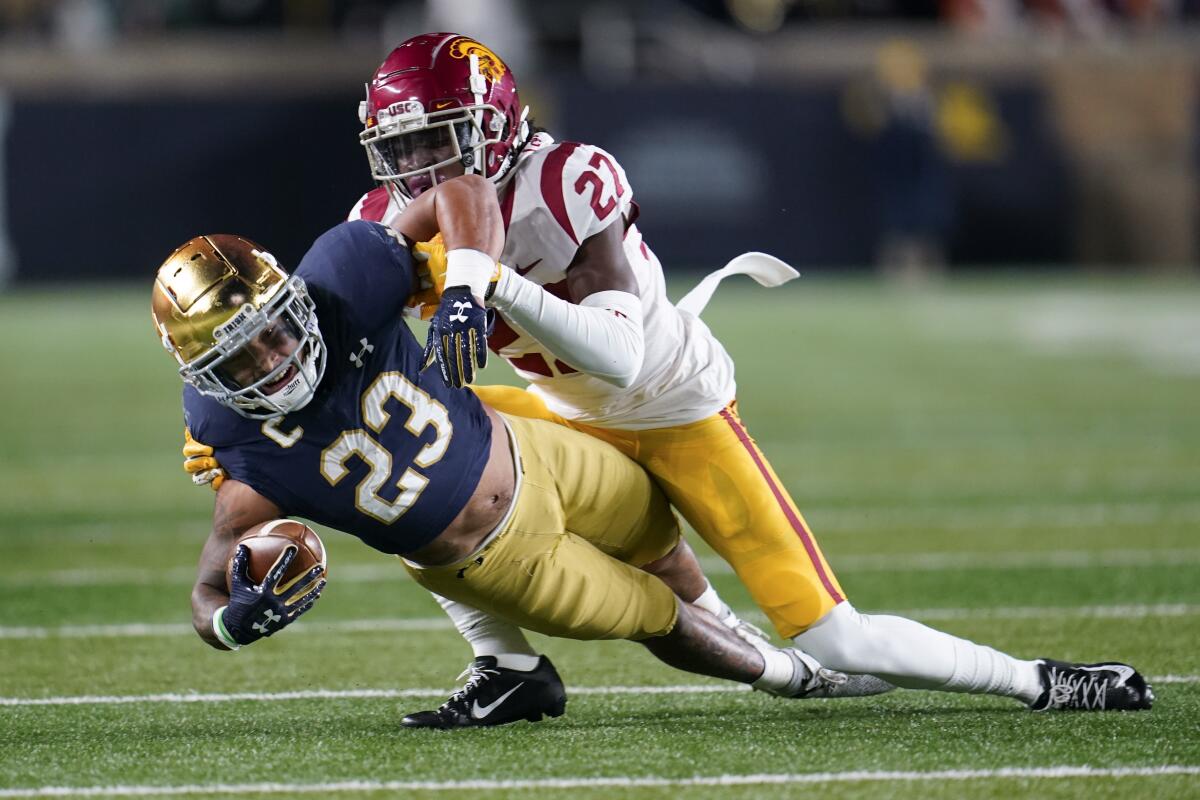 Notre Dame running back Kyren Williams stretches for yardage as he is tackled by USC safety Calen Bullock.