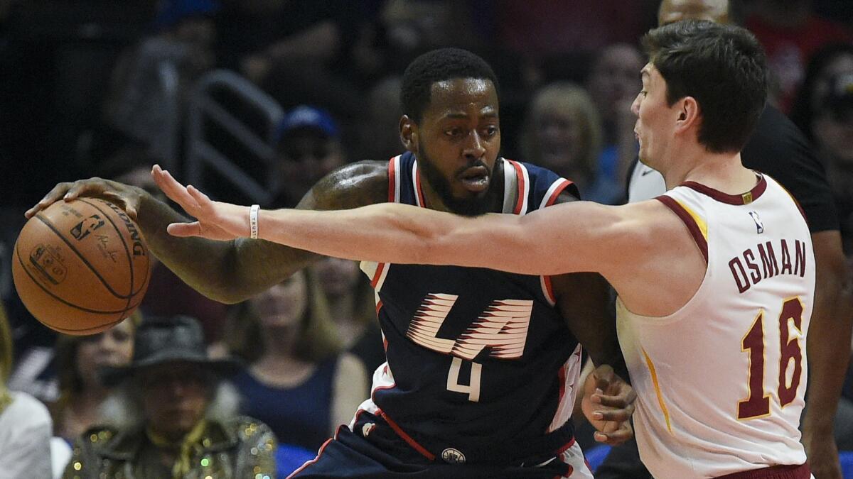 Clippers forward JaMychal Green posts up against Cleveland forward Cedi Osman during a game on March 30.