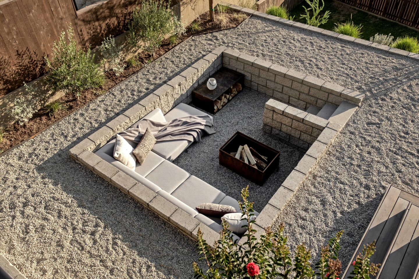 The backyard unfolds layers with tiers of various planters, decks and a sunken conversation/fire pit.