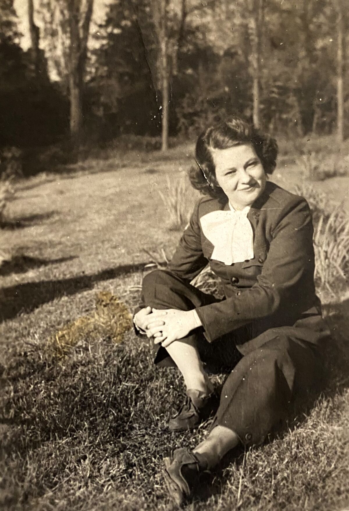 black and white photo of a woman sitting on the grass