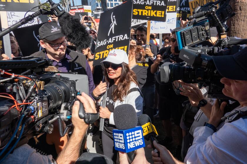 LOS ANGELES, CA - JULY 14: SAG-AFTRA President Fran Drescher, white cap, and National Executive Director and Chief Negotiator Duncan Crabtree-Ireland, left, meet the media at the Netflix picket line in Los Angeles, CA on Friday, July 14, 2023. Actors join striking writers who have been on the picket lines since the beginning of May. (Myung J. Chun / Los Angeles Times)