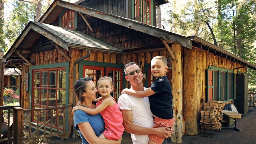 The Donovan family -- Catherine with Bon, 4, and Michael with Tate, 7 -- are pictured in front of their Idyllwild cabin in June. Readers were concerned about what happened to them in the Cranston fire.