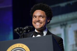 A man smiling behind a pair of microphones at a presidential podium