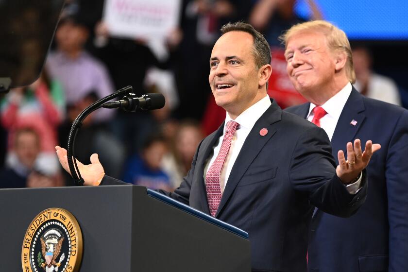 US President Donald Trump (R) smiles behind Kentucky Governor Matt Bevin during a rally at Rupp Arena in Lexington, Kentucky on November 4, 2019. (Photo by MANDEL NGAN / AFP) (Photo by MANDEL NGAN/AFP via Getty Images)