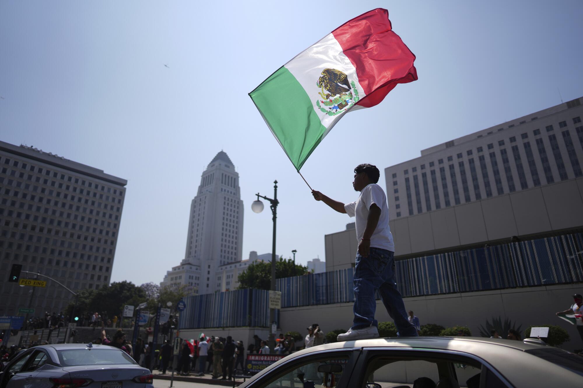 Un manifestante ondea una bandera de México en