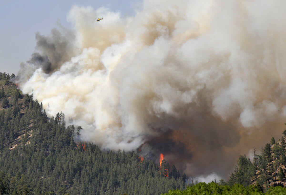 A fast-moving blaze in New Mexico's Santa Fe National Forest prompted evacuations of residences and campgrounds, threatened upscale cabins and vacation homes, and closed a highway.