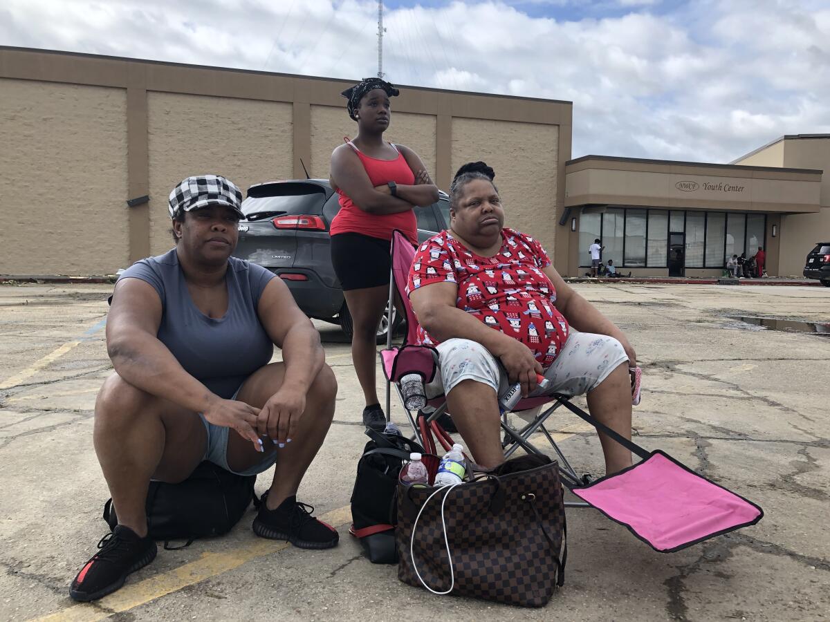 Demetrice Joseph, 47, left, waits with her family at a makeshift drop-off center in LaPlace, La