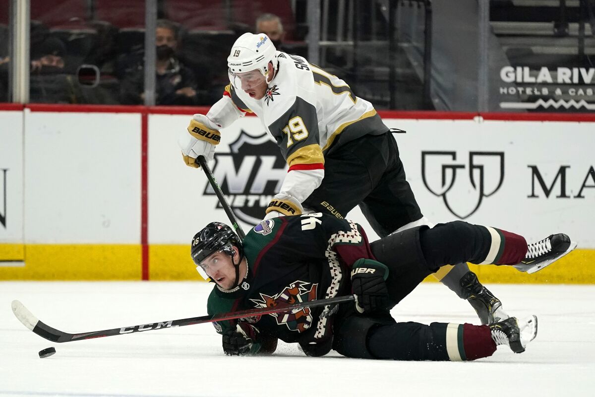 Vegas Golden Knights right wing Reilly Smith (19) sends Arizona Coyotes defenseman Ilya Lyubushkin (46) to the ice during the first period of an NHL hockey game Friday, April 30, 2021, in Glendale, Ariz. (AP Photo/Ross D. Franklin)