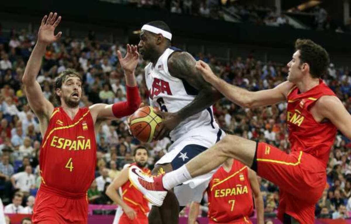 LeBron James drives between Spain's Pau Gasol and Rudy Fernandez during the men's gold-medal basketball game.