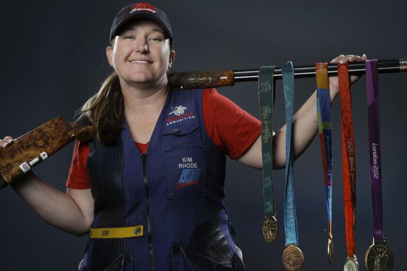 FILE - In this March 8, 2016, file photo, double trap and skeet shooter Kim Rhode poses for photos with her Olympic medals at the 2016 Team USA media summit in Beverly Hills, Calif. Misfortune stacked up like spent shotgun shells in the four years since Kim Rhode won her third Olympic gold medal. (AP Photo/Jae C. Hong, File)