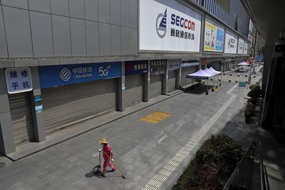 A cleaner walks by the shuttered Huaqiangbei Electronics Market following the coronavirus outbreak in Shenzhen in south China's Guangdong province on Sept. 3, 2022. China has locked down 65 million of its citizens under tough COVID-19 restrictions and is discouraging domestic travel during upcoming national holidays. (Chinatopix Via AP)