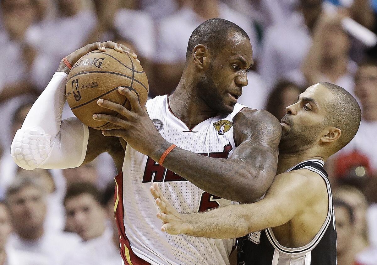 Miami Heat forward LeBron James, left, collides with San Antonio Spurs guard Tony Parker during the Heat's victory in Game 6 of the NBA Finals on Tuesday.