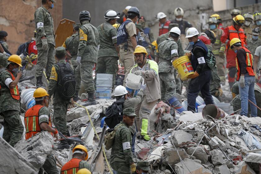 Search and rescue teams remove rubble at a collapsed six-story residential building in Colonia Condesa, in Mexico City.