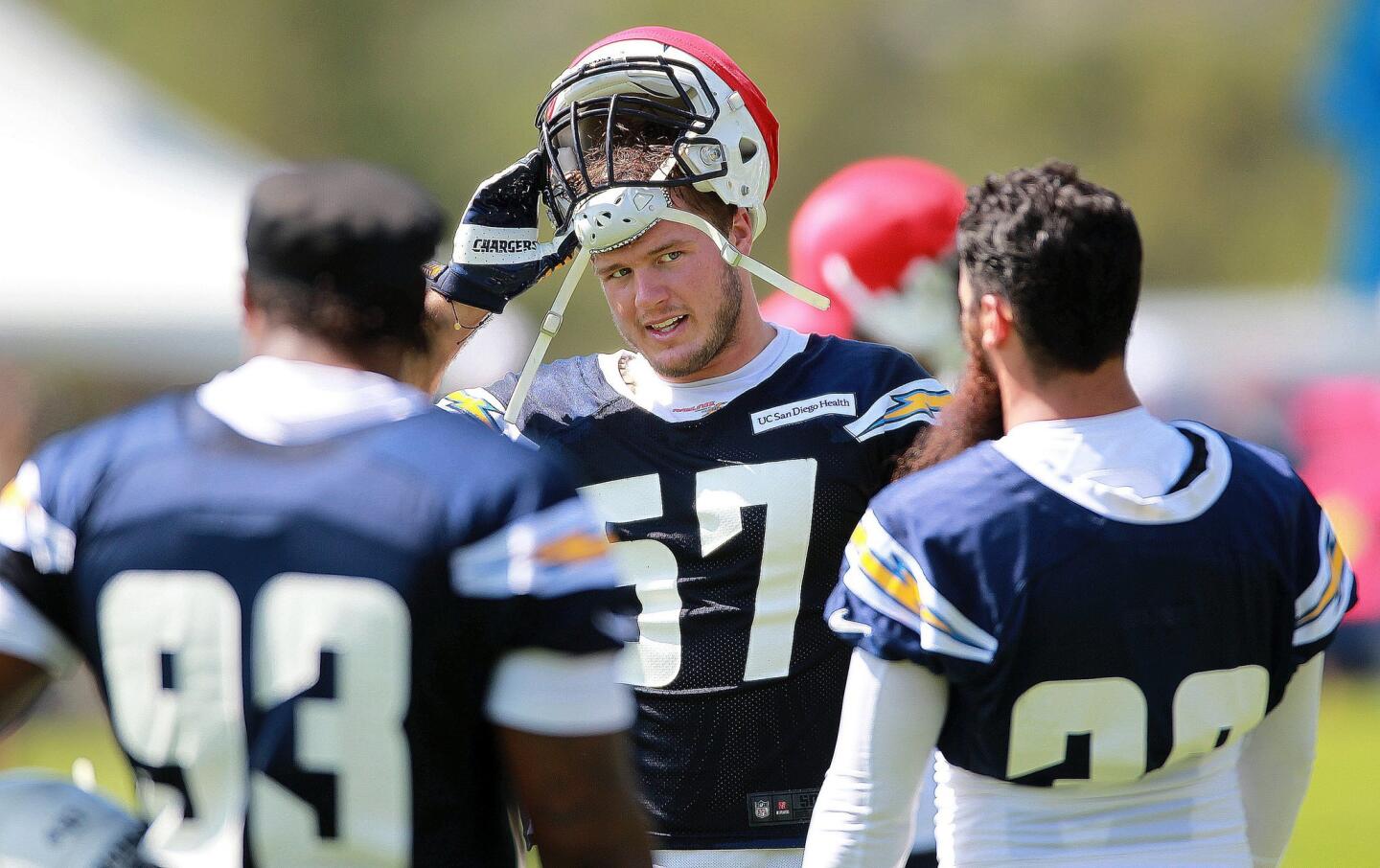 Chargers offensive lineman Colton Underrwood center, worked out with Darius Philon, left, and Eric Weddle during a light moment out on the field at Chargers Park on the first day of camp.