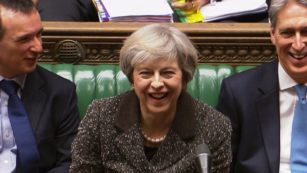 British Prime Minister Theresa May smiles during an exchange in the House of Commons in central London.