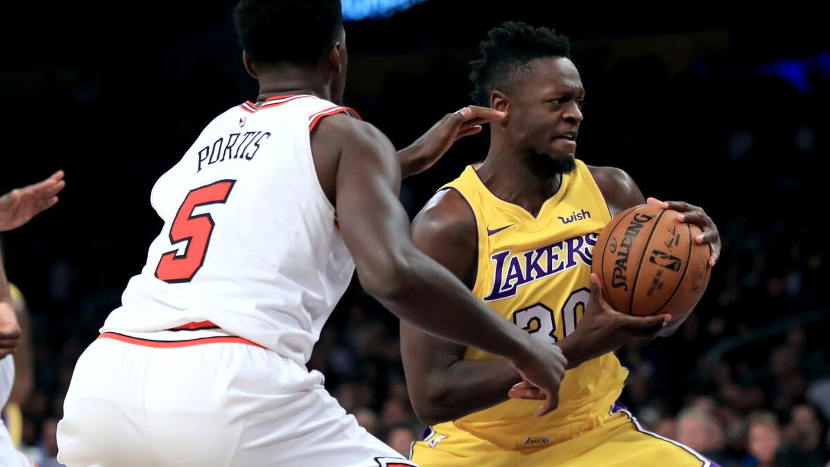 Lakers forward Julius Randle grabs an offensive rebound and looks to score against Bobby Portis and the Bulls.