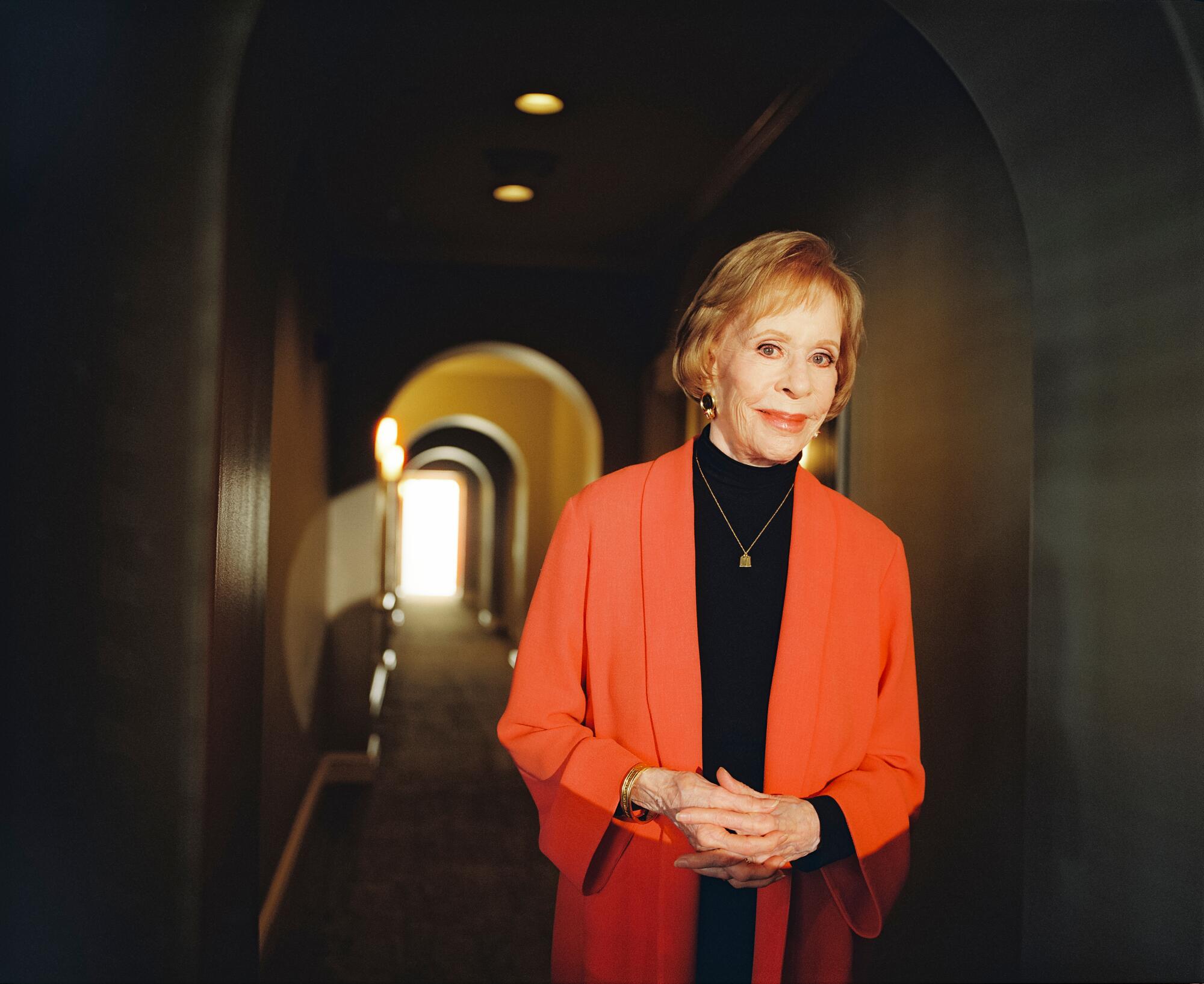 Carol Burnett stands in a long hallway for a photo shoot.