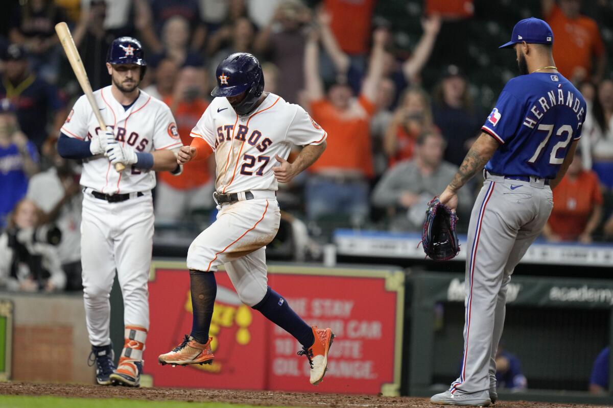 Houston Astros' Jose Altuve (27) scores the winning run on a wild pitch by Texas Rangers relief pitcher Jonathan Hernandez (72) during the 10th inning of a baseball game Wednesday, Sept. 7, 2022, in Houston. (AP Photo/Eric Christian Smith)