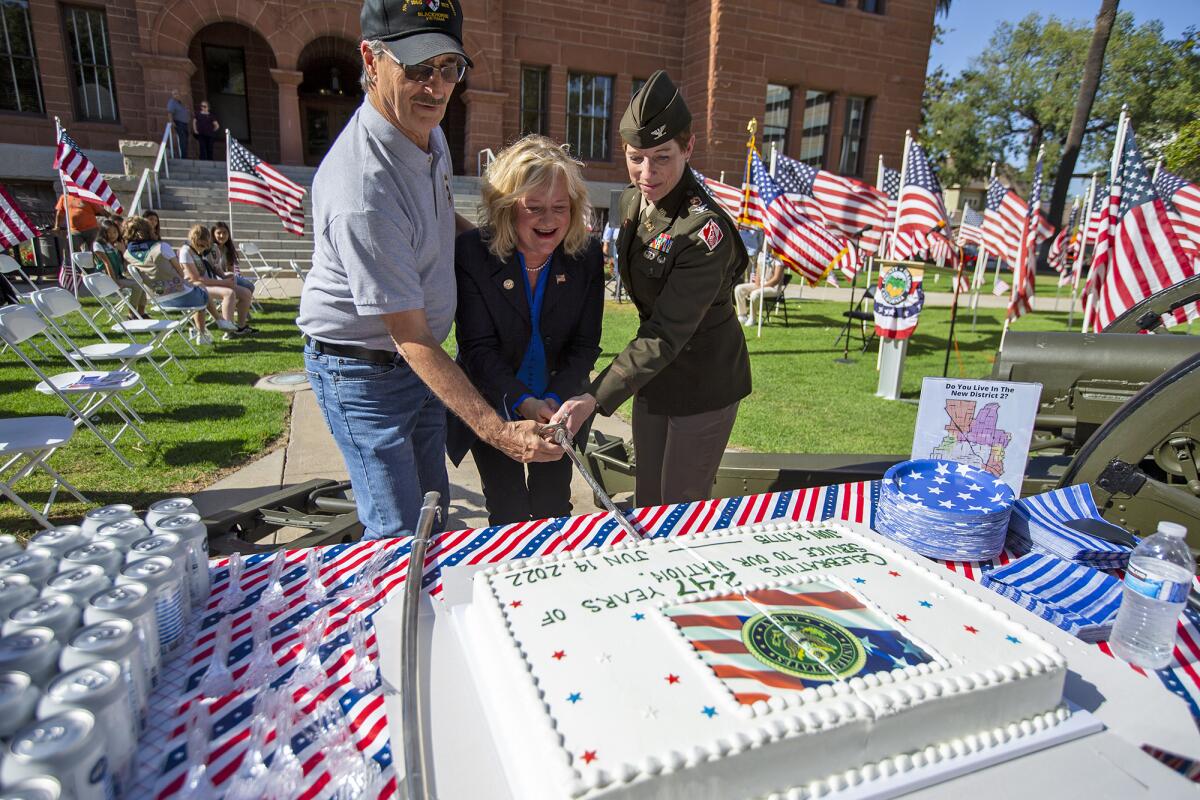 Steve Spriggs, Supervisor Katrina Foley and Col. Julie Balten cut a cake during a Flag Day ceremony.