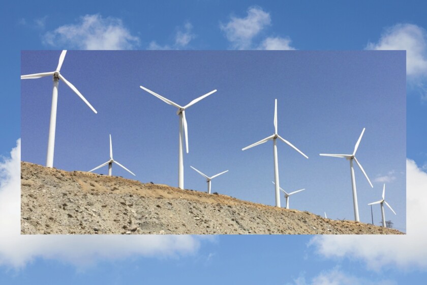 Wind turbines in the desert set against a blue sky.