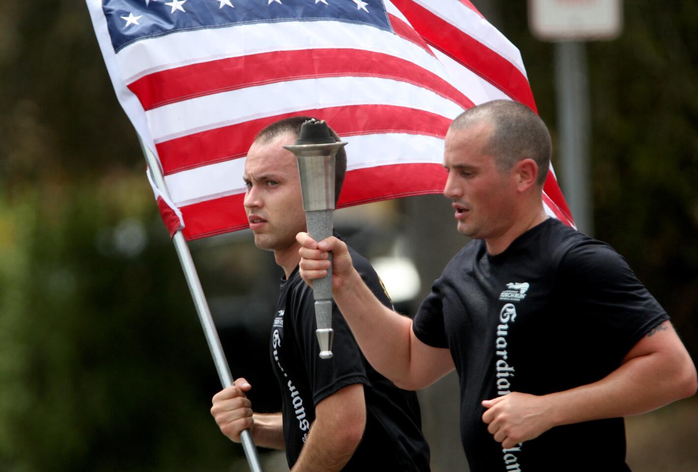 Glendale Police Department cadet Omar Preciado, left, carries the USA flag as detective Jeff Davis carries the Special Olympics torch as they travel south on Chevy Chase Ave. in Glendale on Wednesday, June 10, 2015.