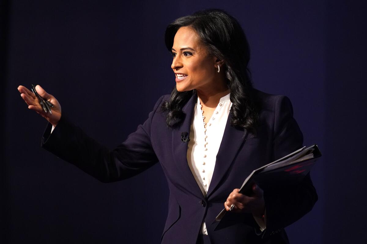 Kristen Welker holds a stack of papers and gestures with a pen.
