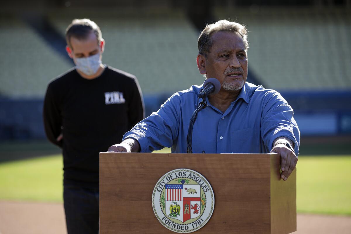 Gil Cedillo speaks at a lectern at Dodger Stadium.