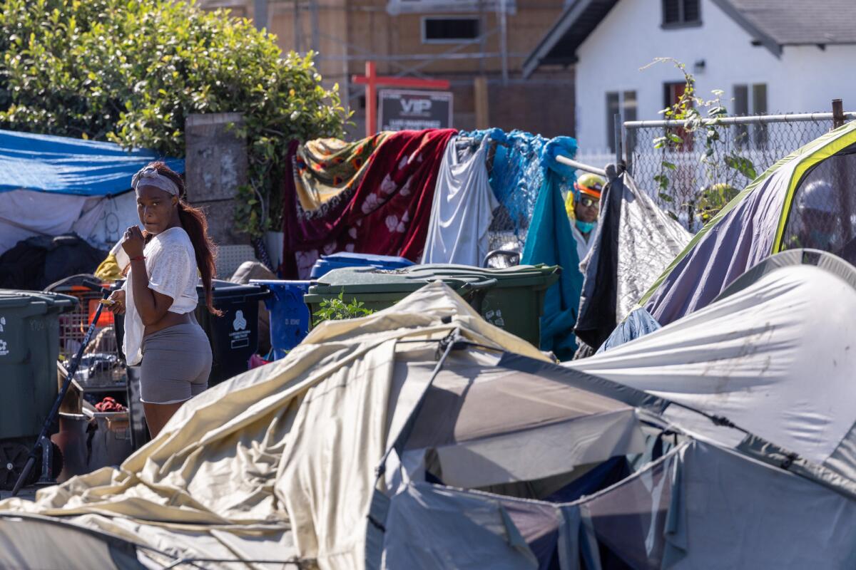 Tatayana Noles gathers up belongings at an encampment in Los Angeles.
