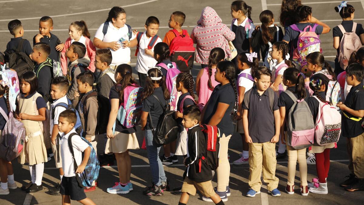 Los estudiantes de Dolores Huerta Elementary School en Los Angeles forman filas en el patio escolar en el primer día de escuela en agosto.