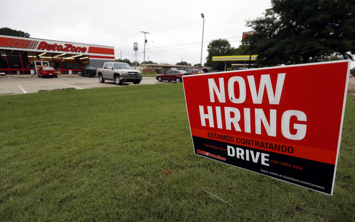 A bilingual "help wanted" sign for Auto Zone is posted outside the store in Canton, Miss., in September.