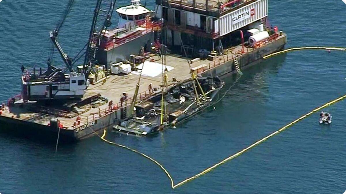 Esta foto de video proporcionada por NBC/LA muestra el casco quemado del Concepción siendo sacado a la superficie por un equipo de salvamento de la Isla Santa Cruz .