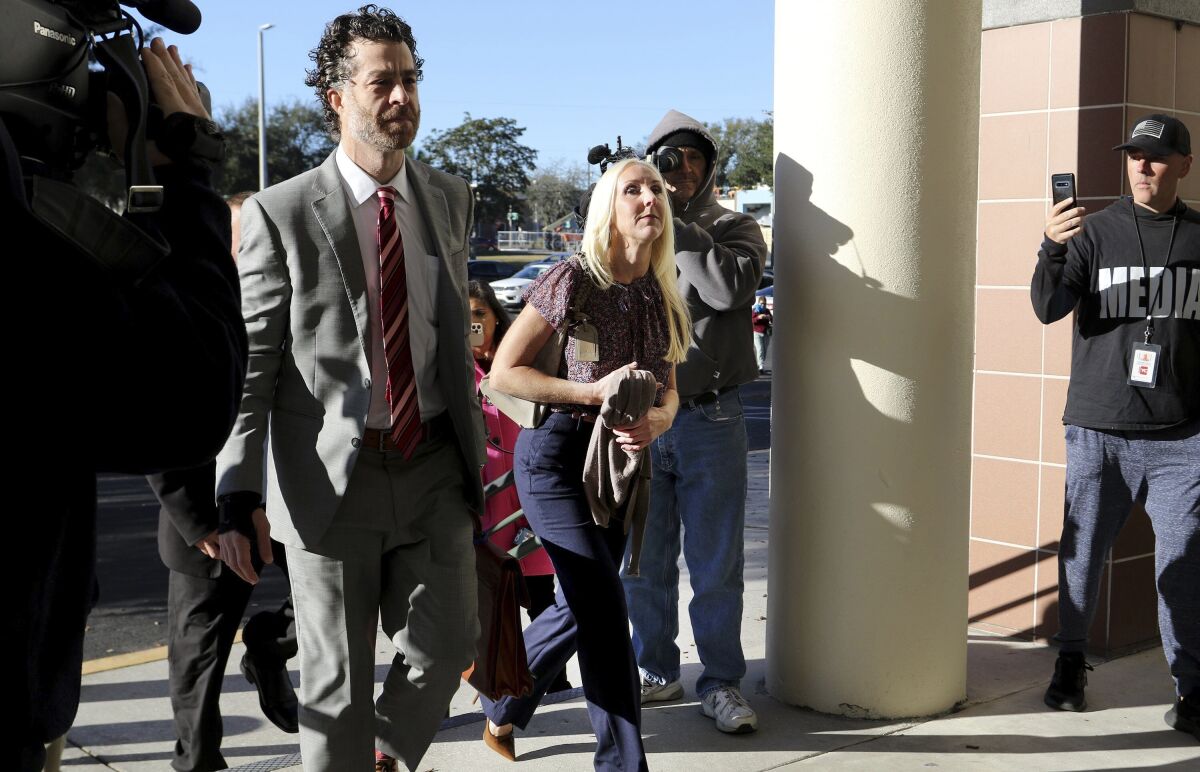 Nicole Oulson, center, arrives for the start of the second-degree murder trial for former Tampa Police Captain Curtis Reeves on Monday, Feb 14, 2022, at the Robert D. Sumner Judicial Center in Dade City. Reeves is accused of shooting and killing Nicole's husband, Chad Oulson, at a Wesley Chapel movie theater in January 2014. (Douglas R. Clifford/Tampa Bay Times via AP)