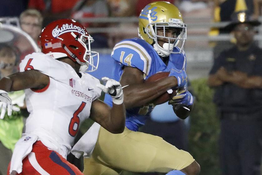 UCLA wide receiver Theo Howard breaks away for a touchdown after making catch in front of Fresno State defensive back Tank Kelly in the second quarter on Saturday.