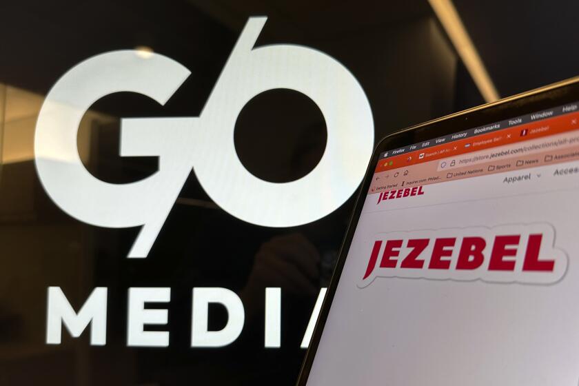 The red-lettered logo of Jezebel is displayed on a laptop screen with the black and white G/O Media logo behind it