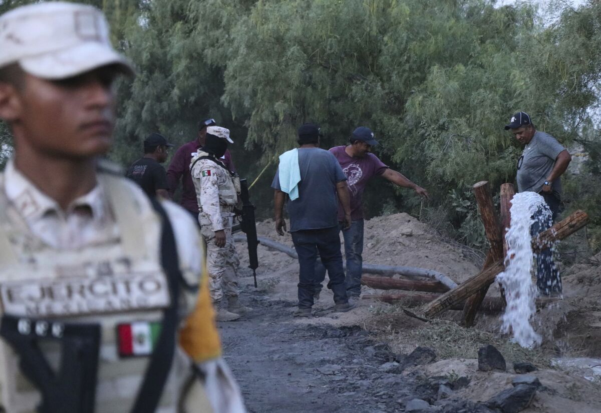 Voluntarios drenan agua de una mina de carbón inundada y colapsada donde varios mineros quedaron atrapados