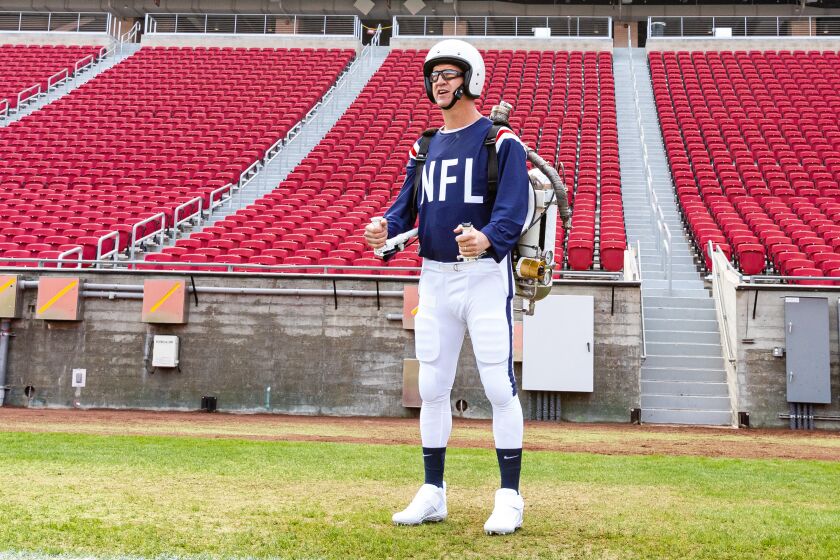 Peyton Manning wears a jet pack to simulate a portion of the Super Bowl I halftime show.